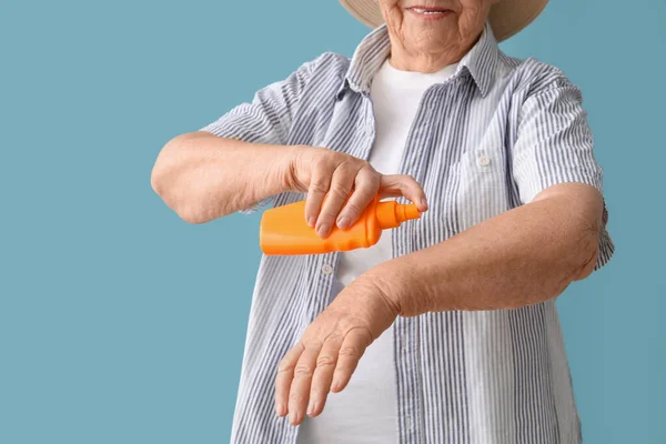 Seniorin Mit Sonnencreme Auf Blauem Hintergrund Nahaufnahme — Stockfoto