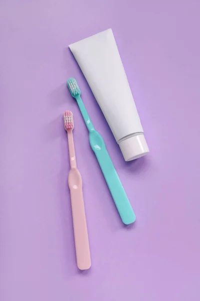 Пластиковые Зубные Щетки Паста Сиреневом Фоне — стоковое фото