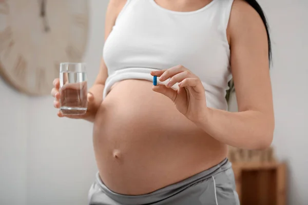 葉酸の錠剤と自宅で水のガラスを持つ妊婦 クローズアップ — ストック写真
