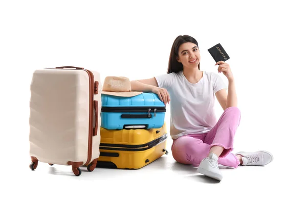 持护照和手提箱坐在白色背景上的年轻妇女 — 图库照片