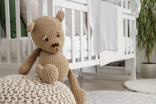 Cute teddy bear on ottoman in children\'s room