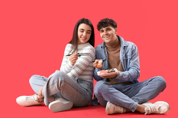 Young Couple Eating Sushi Red Background — Stock Photo, Image
