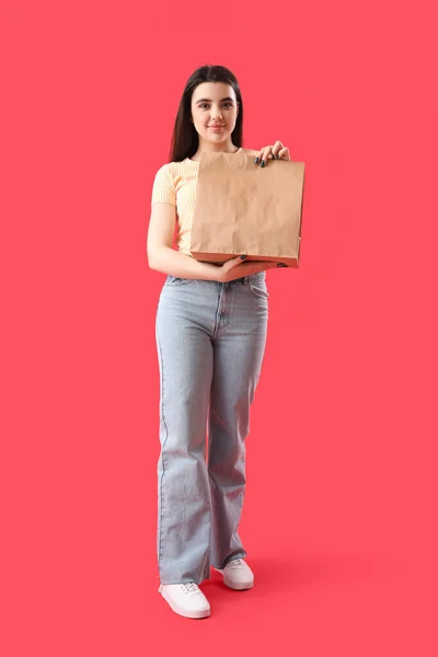 赤い背景に寿司の紙袋を持つ若い女性 — ストック写真