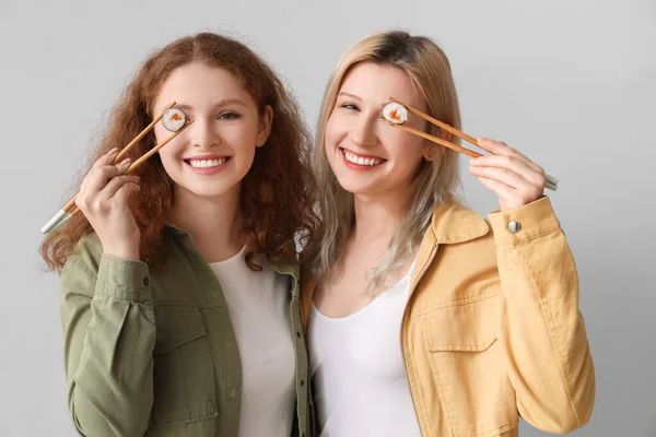 Jonge Vrouwen Met Sushi Rollen Lichte Achtergrond — Stockfoto