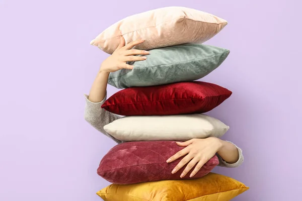 ライラック壁の近くにスタイリッシュな枕を持つ女性 — ストック写真