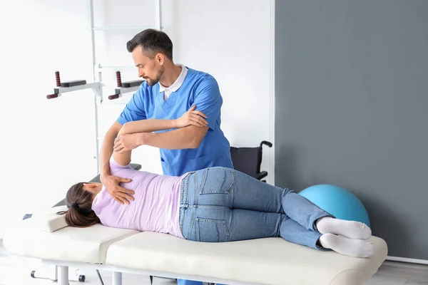 Männlicher Physiotherapeut Arbeitet Mit Junger Frau Auf Couch Reha Zentrum — Stockfoto