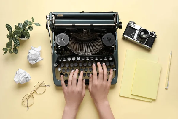 Vrouw Typen Typemachine Met Notebooks Bril Camera Lichtgele Achtergrond — Stockfoto