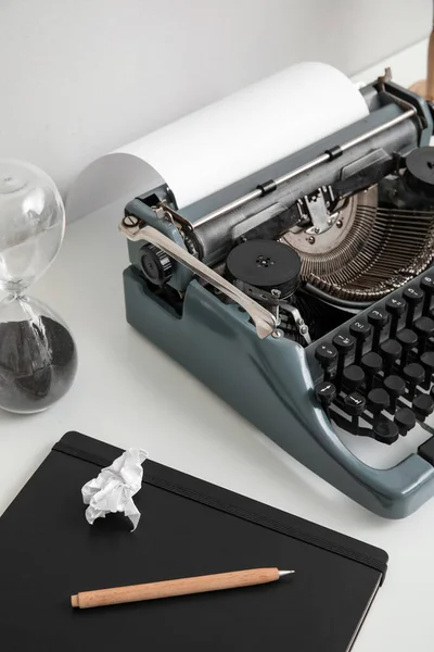 Máquina Escrever Vintage Com Ampulheta Caderno Mesa Branca Perto Parede — Fotografia de Stock