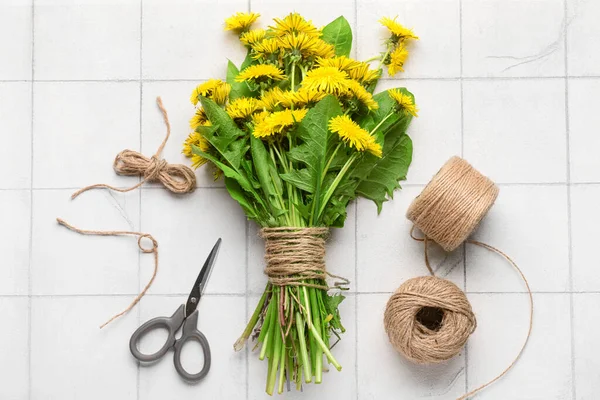 stock image Bouquet of beautiful dandelion flowers, rope and scissors on light tile background