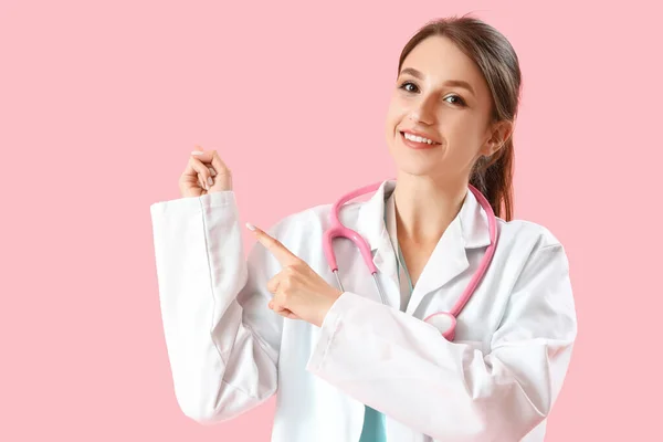 Vrouwelijke Medische Stagiaire Wijst Naar Iets Roze Achtergrond — Stockfoto