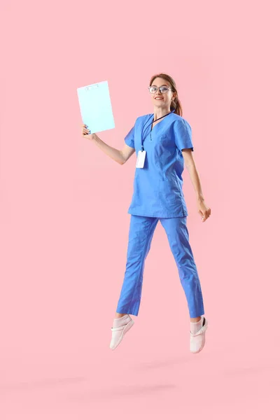 Female Medical Intern Clipboard Jumping Pink Background — Stock Photo, Image