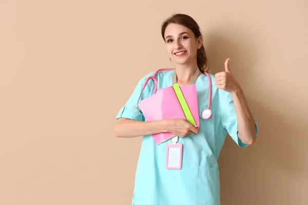 Female Medical Intern Copybooks Showing Thumb Beige Background — Stock Photo, Image