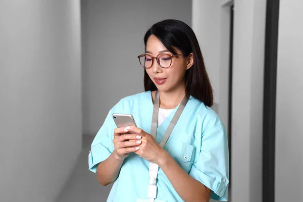 Kvinnlig Asiatisk Läkare Som Använder Mobiltelefon Kliniken — Stockfoto