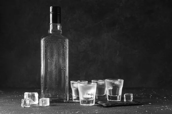 Schüsse Und Eine Flasche Wodka Mit Eiswürfeln Auf Schwarzem Hintergrund — Stockfoto