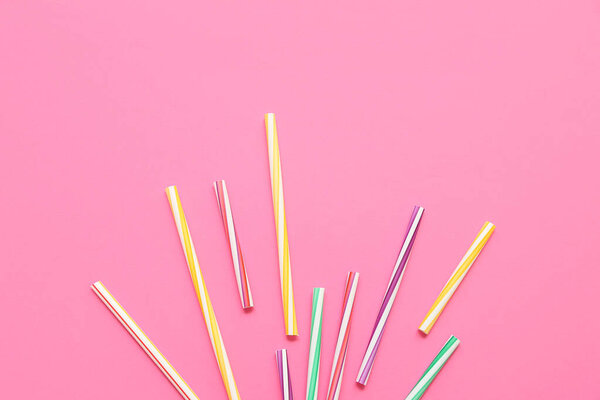 Различные соломинки на розовом фоне