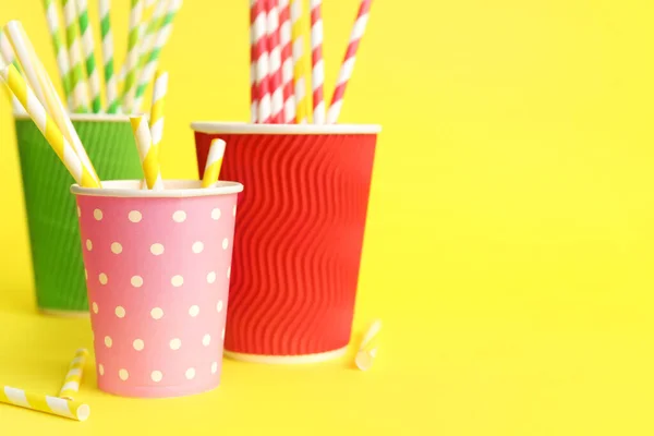 stock image Paper cups with different drinking straws on yellow background