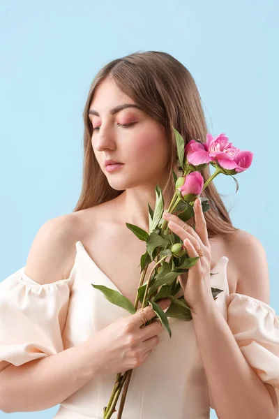 Mavi Arka Planda Şakayık Çiçekleri Olan Güzel Genç Bir Kadın — Stok fotoğraf