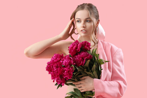 Красивая молодая женщина с букетом пионских цветов на розовом фоне