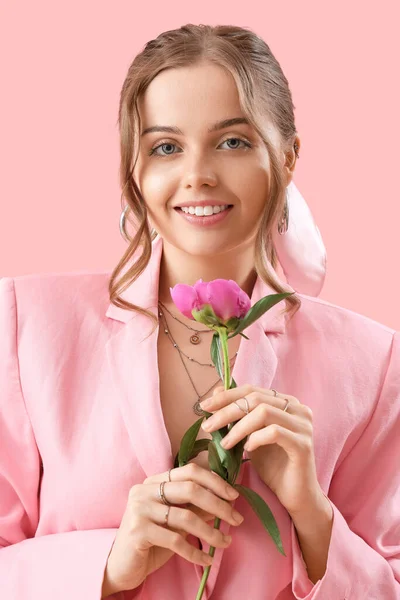 ピンクの背景に牡丹の花を持つ美しい若い女性 — ストック写真