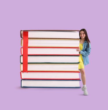 Mutlu genç bir kadın ve leylak arka planıyla ilgili bir yığın kitap.