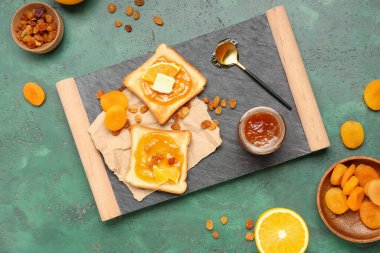 Turuncu reçelli ve yeşil grunge arkaplanlı lezzetli tostlar.