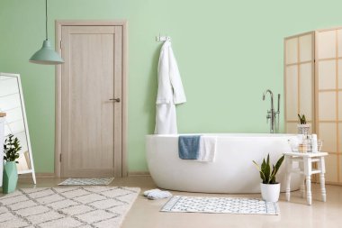 Küvetli, bornozlu ve katlanır perdeli bir banyo.