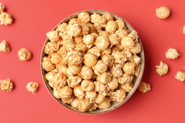 Kırmızı arka planda gevrek patlamış mısır kasesi.