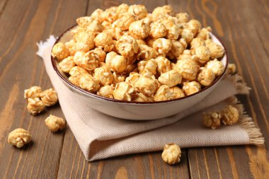 Tahta arka planda gevrek patlamış mısır kasesi.