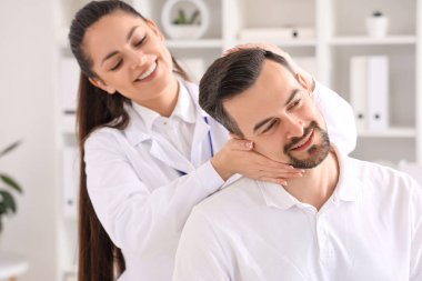 Rehabilitasyon merkezinde genç bir adamla çalışan kadın fizyoterapist.