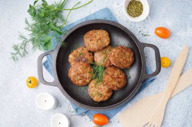 Mutfaktaki mavi grunge masasında pirzola, dereotu ve domatesli kızartma tavası.