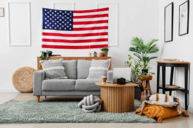 Oturma odasının içinde ABD bayrağı ve kanepesi asılı.