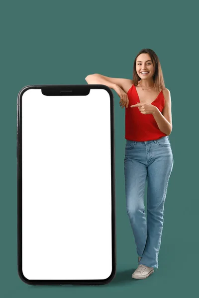 Šťastná Mladá Žena Ukazuje Velký Mobilní Telefon Prázdnou Obrazovkou Zeleném — Stock fotografie