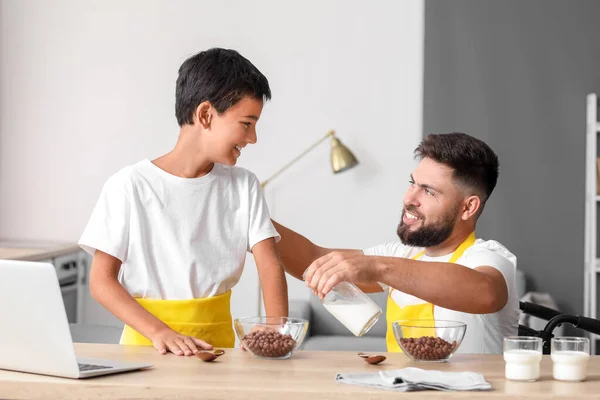 Father Wheelchair Pouring Milk His Little Son Bowl Home — Stock Photo, Image