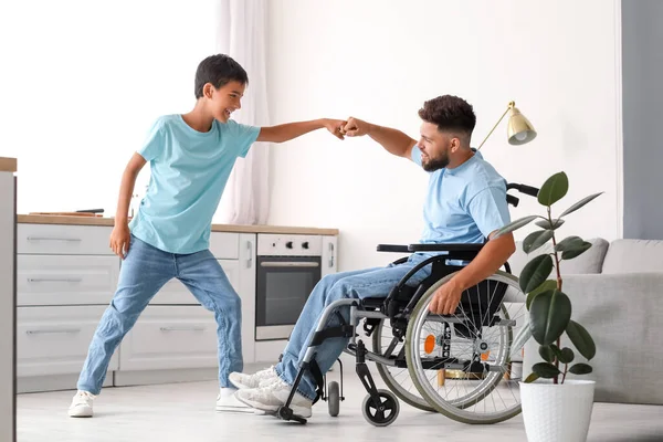 車椅子の少年と父親が家で拳をぶつける — ストック写真
