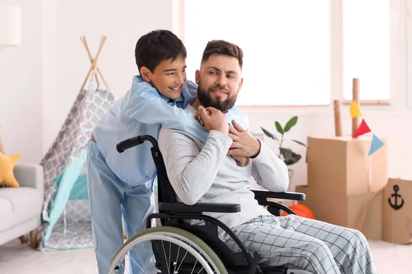 車椅子の少年と父親が家で抱き合って — ストック写真