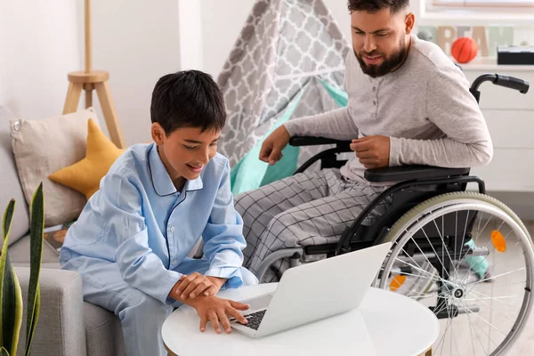 Mały Chłopiec Jego Ojciec Wózku Inwalidzkim Używają Laptopa Domu — Zdjęcie stockowe