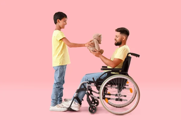 Little Boy His Father Wheelchair Toy Pink Background — Stock Photo, Image
