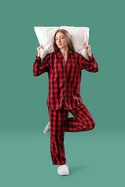 Yeşil Arka Planda Yastıklı Pijamalı Genç Bir Kadın — Stok fotoğraf