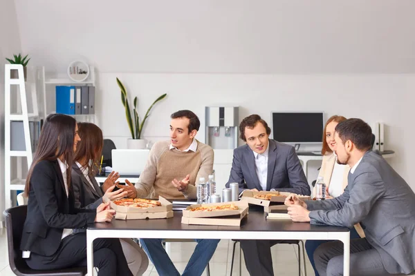 一群在办公室里拿着美味披萨的商人 — 图库照片