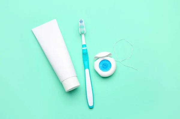 Zahnseide Bürste Und Tube Zahnpasta Auf Türkisfarbenem Hintergrund — Stockfoto
