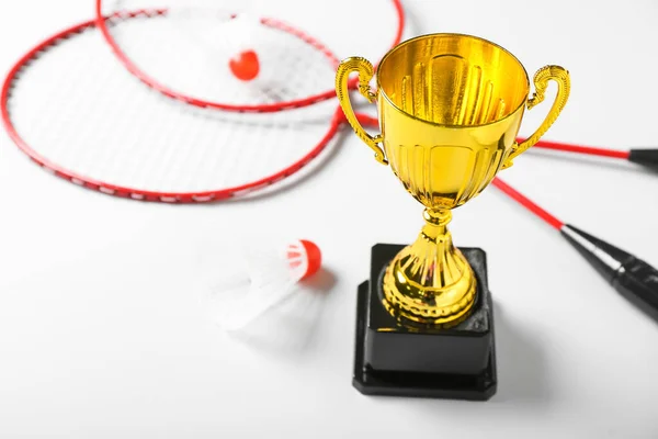 Goldpokal Mit Badmintonschlägern Und Federbällen Auf Hellem Hintergrund Nahaufnahme — Stockfoto
