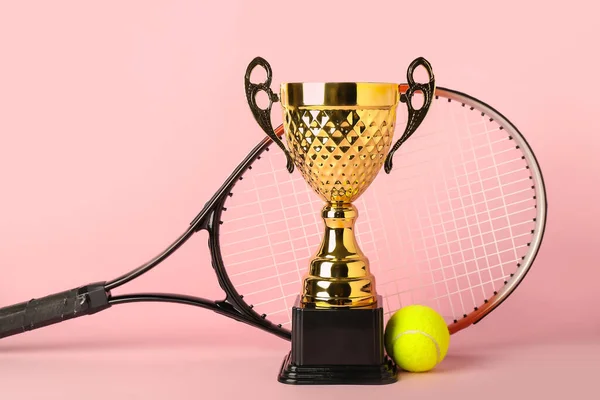 Goldbecher Mit Tennisschläger Und Ball Auf Rosa Hintergrund — Stockfoto