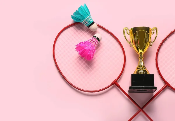 Goldpokal Mit Badmintonschlägern Und Federbällen Auf Rosa Hintergrund — Stockfoto