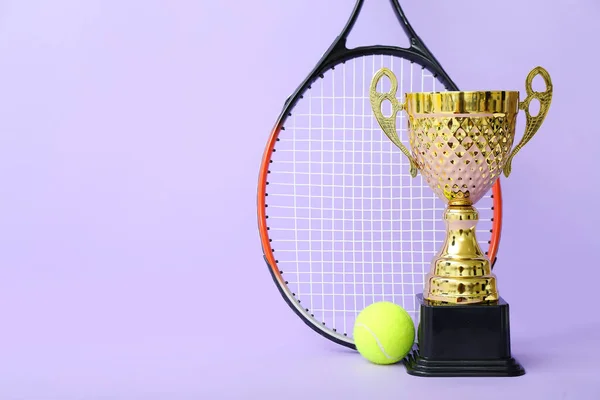Goldbecher Mit Tennisschläger Und Ball Auf Fliederfarbenem Hintergrund — Stockfoto