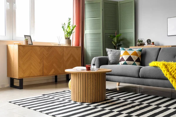 居心地の良いグレーのソファ コーヒーテーブル 木製キャビネット付きの明るいリビングルームのインテリア — ストック写真