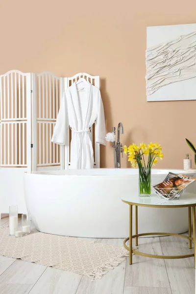 浴槽とナルシシズムの花のあるバスルームのインテリアテーブル — ストック写真