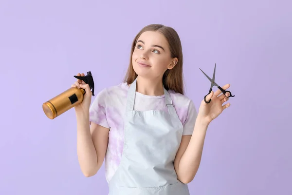 stock image Female hairdresser with scissors and spray on lilac background