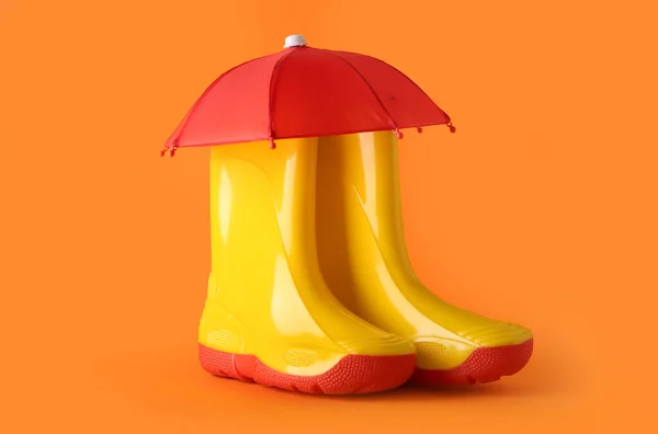 Composición Creativa Con Botas Goma Mini Paraguas Sobre Fondo Naranja — Foto de Stock