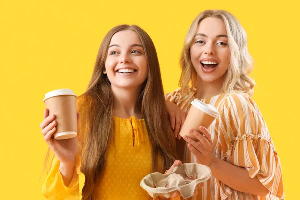 Junge Schwestern Mit Tassen Kaffee Auf Gelbem Hintergrund — Stockfoto