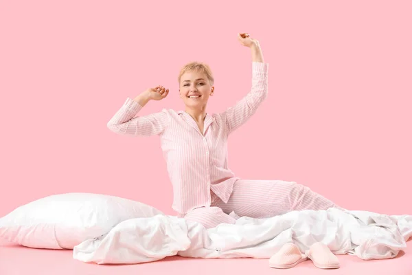 Pembe Arka Planda Yumuşak Battaniye Yastıkla Uyanık Genç Bir Kadın — Stok fotoğraf